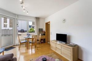 a living room with a television and a table with chairs at Fewo Ricken am Kurpark in Willingen