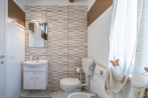 a bathroom with a toilet and a sink and a mirror at Le tre pigne in Floridia +17 photos