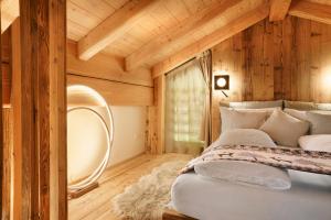 a bedroom with a bed with a wooden wall at Luxury Chalet Giulia in Torcegno