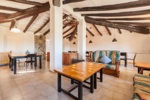 a living room with wooden tables and chairs at Masia Alt in Olerdola