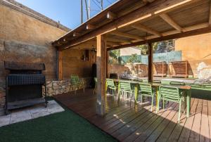 a patio with a table and chairs and a fireplace at Masia Alt in Olerdola