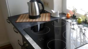 a kitchen counter with a coffee pot on a stove at Ferienwohnung Schmidt in Krummhörn