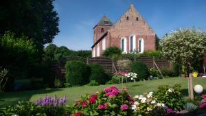 a church with a bunch of flowers in front of it at Ferienwohnung Schmidt in Krummhörn