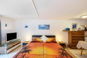 a bedroom with a bed and a flat screen tv at Spessartruhe in Linsengericht
