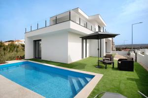 a white house with a swimming pool and an umbrella at Villa Atlantic View in Salir de Porto