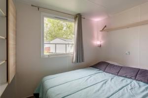 a bedroom with a bed and a window at Mobil-home in Angles +13 photos