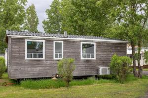 a small house in a yard with trees at Mobil-home in Angles