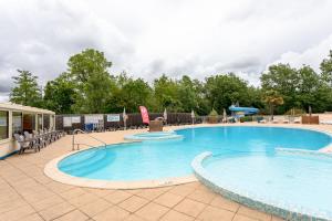 a large swimming pool with chairs around it at Mobil-home in Angles