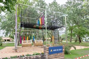 a bird cage with balls in it in a park at Mobil-home in Angles