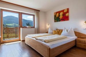 a bedroom with a large bed and a large window at Huberhof App Golden Delicious in Feldthurns