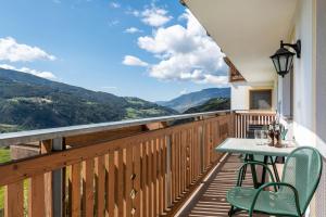 a balcony with a table and chairs and a view at Huberhof App Golden Delicious in Feldthurns