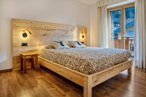 a bedroom with a large bed with a wooden headboard at Condominio Lucia 7 Pinzolo in Pinzolo