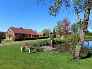 a park bench sitting in the grass next to a lake at Dat Jollenhuus in Ihlow
