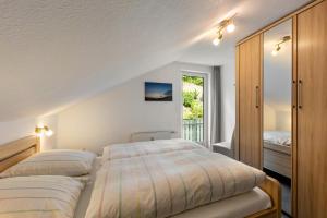 a bedroom with two beds and a balcony at Ferienwohnung Hacke in Schmallenberg