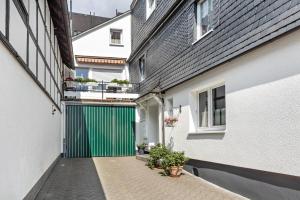 an alley between two buildings with a green door at Ferienwohnung Hacke in Schmallenberg