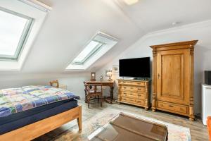 a bedroom with a bed and a flat screen tv at Ferienwohnung Zur Henne in Weinbach