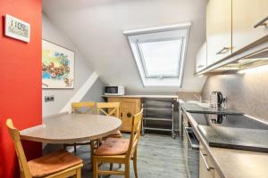 a kitchen with a table and chairs and a sink at Ferienwohnung Zur Henne in Weinbach