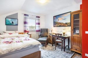 a bedroom with a bed and a desk and a table at Ferienwohnung Zur Henne in Weinbach