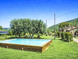 a swimming pool in a field with trees and a house at Apartment Cotoneaster by Interhome in Perugia
