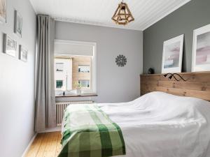 a bedroom with a bed with a green and white blanket at Apartment Alegränd by Interhome in Falkenberg