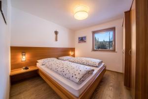 a bedroom with a bed and a window at Ferienwohnung Kratzberg Edelweiss in Avelengo