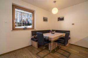 a dining room with a wooden table and chairs at Ferienwohnung Kratzberg Edelweiss in Avelengo