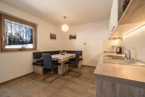 a kitchen with a table and a couch in a room at Ferienwohnung Kratzberg Edelweiss in Avelengo