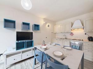 a kitchen with a table with chairs and a tv at Apartment Marmolada-13 by Interhome in Alba di Canazei