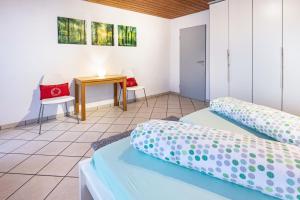 a bedroom with two beds and a table and a desk at Ferienwohnungen Haus Birgit in Günzgen
