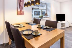a dining room table with chairs and a television at Ferienwohnungen Haus Birgit in Günzgen