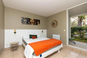 a bedroom with a bed and a large window at Appartement Bisbau in Moliets-et-Maa +13 photos