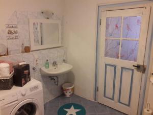 a bathroom with a sink and a washing machine at Ferienwohnung Sternenhof in Breisach am Rhein +2 photos