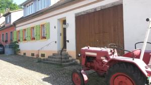 a red tractor parked in front of a building at Ferienwohnung Sternenhof in Breisach am Rhein
