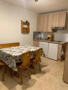 a kitchen with a table and some chairs and a table and a kitchen at Appt de montagne Araches in Arâches-la-Frasse