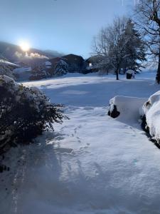 a path covered in snow with the sun in the background at Appt de montagne Araches in Arâches-la-Frasse +2 photos