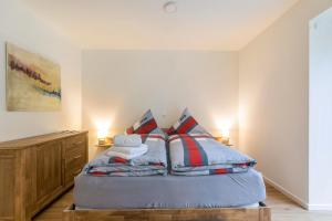 a bedroom with a bed with pillows on it at Willewatt Wohnung 1 in Husby