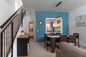 a dining room and kitchen with a blue wall at Las Velas 37 in Meloneras
