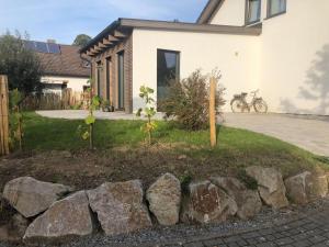 a garden in front of a house with rocks at Ferienwohnung Haas Oberschopfheim in Friesenheim