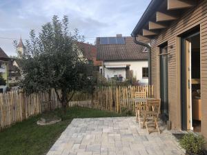a patio with two chairs and a wooden fence at Ferienwohnung Haas Oberschopfheim in Friesenheim +2 photos