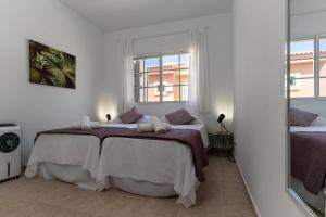 a bedroom with two beds and two windows at Las Velas 37 in Meloneras +19 photos