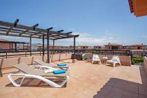 a row of lounge chairs on a roof at Encantadora Casa Tara in Lajares