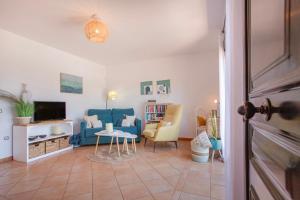 a living room with a blue couch and chairs at Encantadora Casa Tara in Lajares