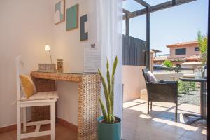 a patio with a table and a potted plant at Encantadora Casa Tara in Lajares