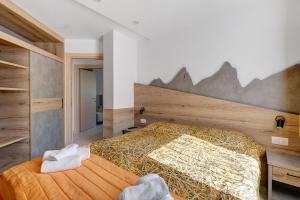 a bedroom with a large bed with a wooden wall at Night and day 8 in Predazzo