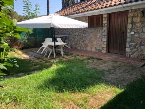 a patio with an umbrella and a table and chairs at La Capannuccia D in Ansedónia