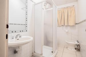 a bathroom with a shower and a sink and a toilet at La Capannuccia D in Ansedónia +4 photos