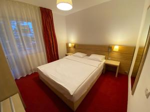 a bedroom with a white bed and a window at Vila Amira Predeal in Predeal