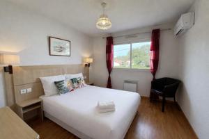 a bedroom with a large white bed and a window at Villa Casa Brisa, pour 6 voyageurs, proche des plages à 8 minutes en vélo in Capbreton