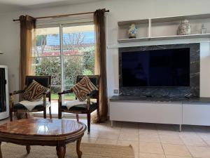 a living room with a television and a fireplace at Villa Casa Brisa, pour 6 voyageurs, proche des plages à 8 minutes en vélo in Capbreton