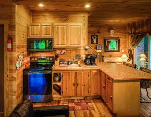 a kitchen with wooden cabinets and a stove top oven at Tree House in Helen